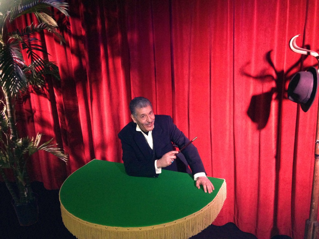 Le magicien Zargal Max devant le rideau rouge à la table de close-up verte pour la soirée magie